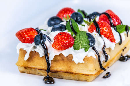 Waffles with whipped cream and fresh fruit. The food in the restaurant. Food styling and restaurant meal serving.の写真素材