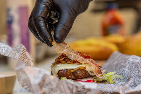 Chef prepares fresh delicious burger with ingredients. Closeup. Fast foodの写真素材