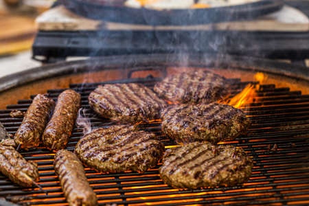 Prepared meat cutlet for burger on grill, closeupの写真素材