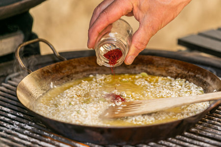 The chef prepares a traditional seafood paella on the grill. Fresh and Colorful Spanish Seafood Paella. Mediterranean cuisine and seafood dishes.の写真素材