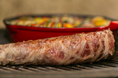 Chef preparing traditional Provençal vegetable dish Ratatouille with stuffed rolled meat on the grill. Healthy eating.の写真素材