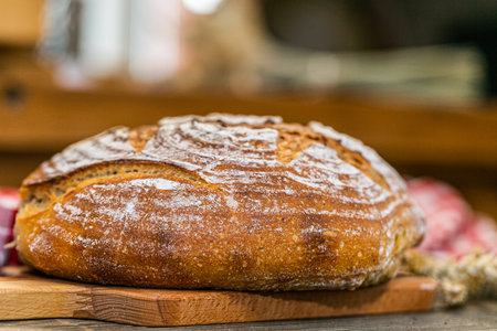 Handmade fresh bread baked with natural ingredients on a wooden board. Close up