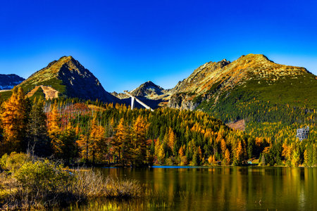 Wide landscape view of the snow-capped mountain range in Slovakia. The peaks are perfectly reflected...