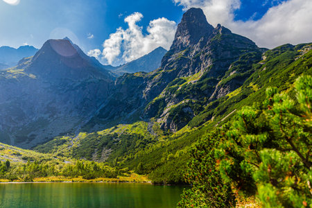 A powerful view of the jagged Jastrabia veza mountain peak reflecting in the emerald waters of...