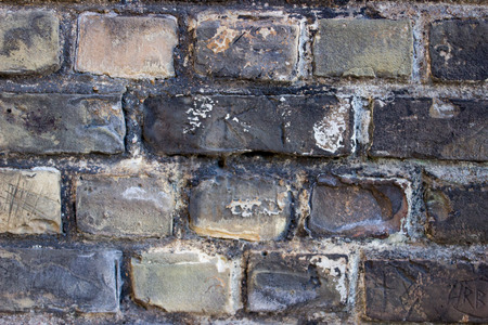 A black and grey old brick wall bacground.の写真素材