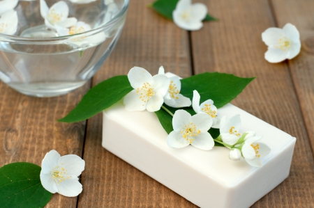 Jasmin flowers and soap on wooden table, selective focusの写真素材
