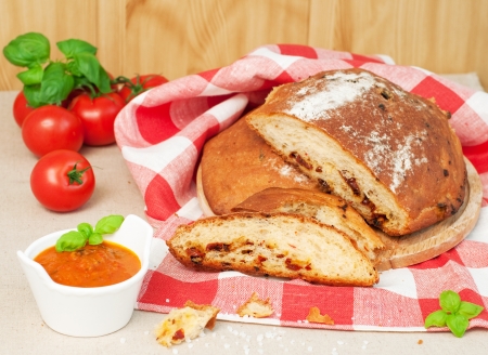 Homemade bread with dried tomatos, fresh basil, tomatoes and sauce, horizontalの写真素材