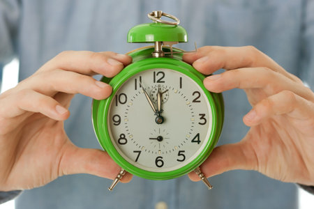 Man holding clock and showing time