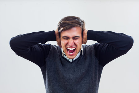 Frustrated businessman is covering his ears and shouting 