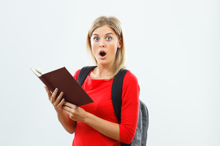 Beautiful female student is surprised because of something she had read in the book.の写真素材