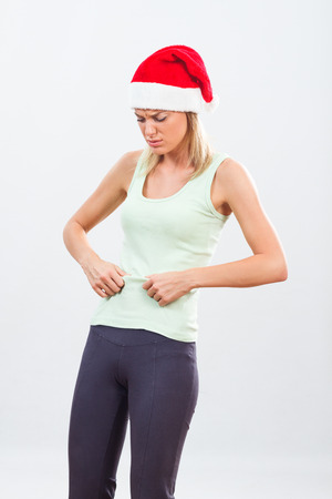 Young woman doesn't feel fit after eating for holidays.の写真素材