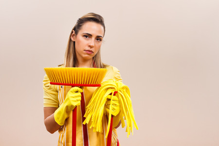Sad housewife is tired of cleaningの写真素材