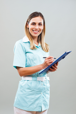 Portrait of beautiful nurse writing notes.の写真素材