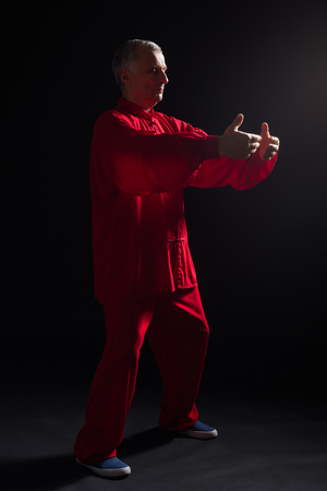 Senior man enjoys exercise Tai Chi indoor.の写真素材