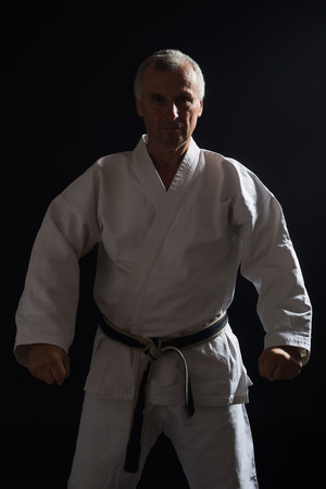 Senior man enjoys practicing karate indoor.の写真素材