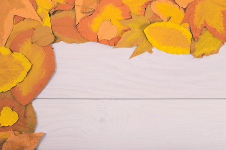 Image of wooden table and painted leaves.Image is intentionally toned.