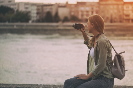 Image of young woman photographing outdoor.Image is intentionally toned.の写真素材