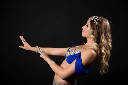 Beautiful belly dancer performing belly dance on black background.の写真素材