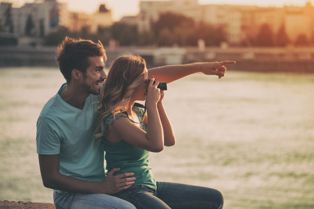 Young happy couple photographing together.Image is intentionally toned.の写真素材