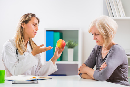 Senior woman patient refusing to eat fruit which is good for her health.の写真素材
