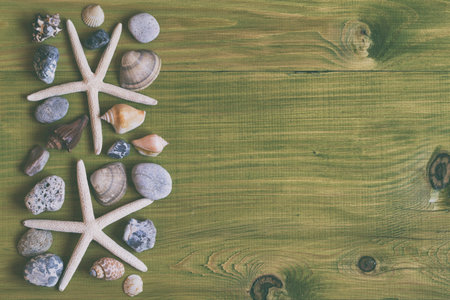 Image of starfish,seashells and stones on wooden table.Image is intentionally toned.