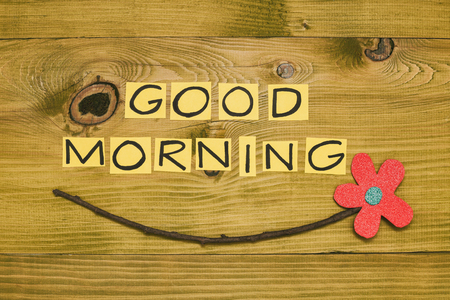 Image of text good morning and flower on wooden table.Toned photo.の写真素材