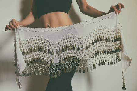 Image of close up stomach of belly dancer holding scarf.Toned photo.の写真素材