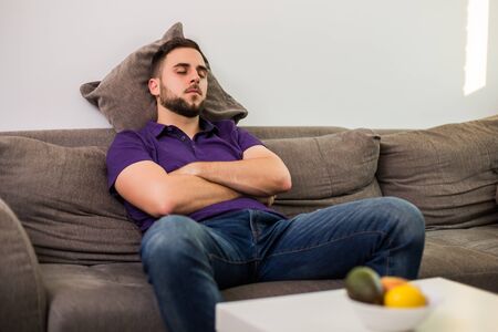 Man fell asleep while  while sitting on sofa  in his living room.の写真素材