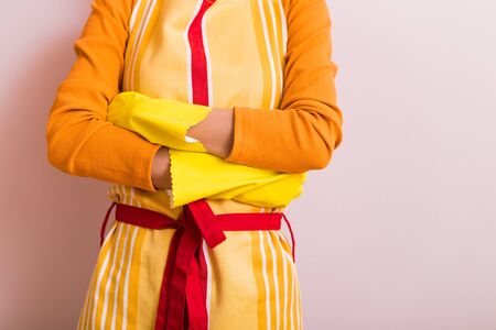 Image of housewife with arms crossed standing in front of wall.の写真素材
