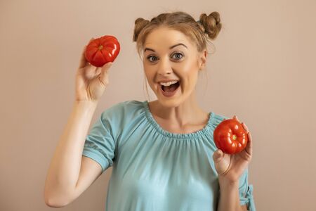 Portrait of cute happy woman holding tomato.Toned image.の写真素材