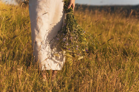 Woman holding bouquet of flowers and enjoys in the nature.の写真素材