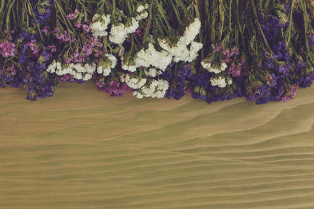 Image of beautiful dried flowers on wooden background.