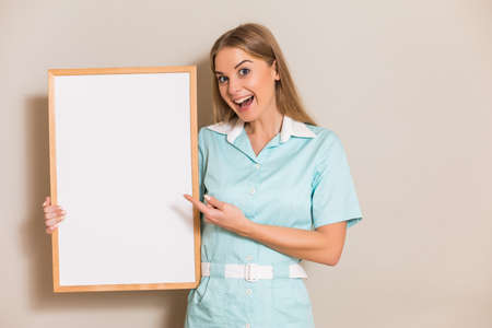 Portrait of  medical nurse pointing at white board.の写真素材
