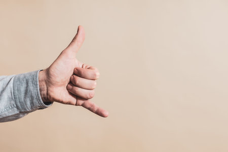 Close up image of male hand showing call me gesture.の写真素材