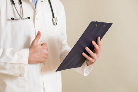 Image of male  doctor showing thumb up and holding documents