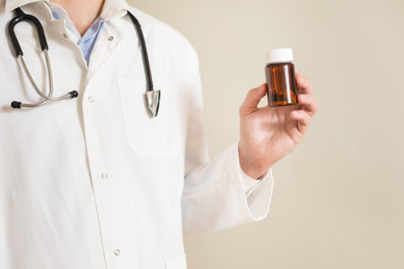 Image of  male  doctor holding bottle of pills.の写真素材