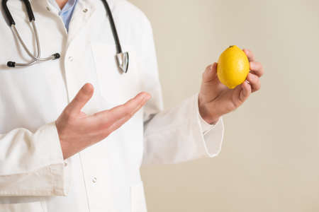 Image of male doctor showing lemon.の写真素材