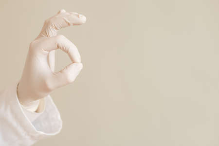 Image of close up hand in protective glove of doctor showing ok sign.の写真素材