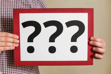 Man showing paper with question marks.