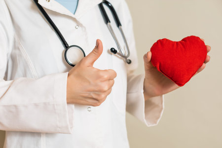 Image of  female doctor showing heart shape and thumb up.
