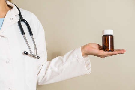 Image of  female  doctor holding bottle of pills.の写真素材