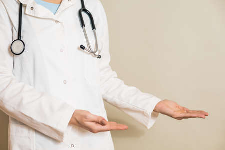 Image of female doctor showing showing welcome gesture.の写真素材