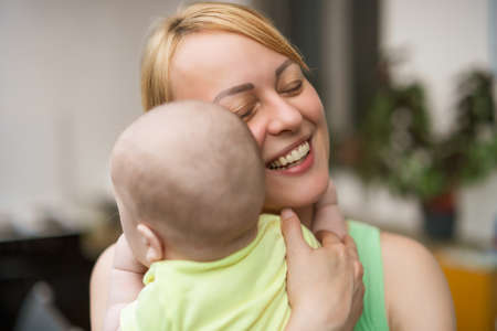 Mother enjoys spending time with  her little cheerful baby boy.の写真素材