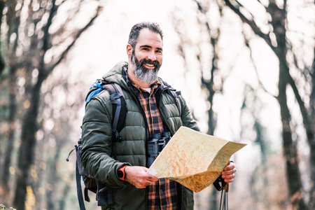 Image of man hiking and looking at map.
