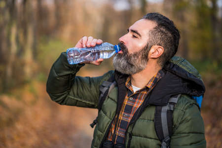 Image of man  drinking water while hiking.の写真素材
