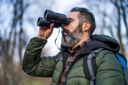 Image of man hiking and using binoculars.