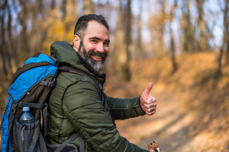 Hiker showing thumb up while hiking in nature.の写真素材