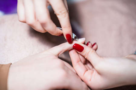 Close up image of manicure process ,removal of nail cuticle nail with nail clipper. Focus on fingernail.の写真素材