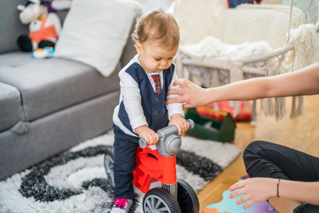 Image of cute little baby boy riding his first bike.の写真素材