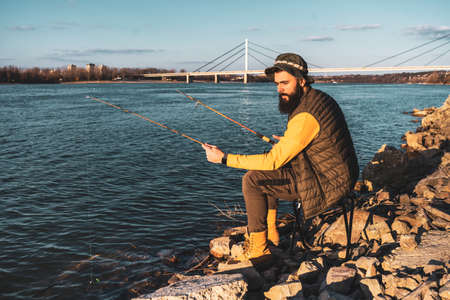 Man enjoys fishing by a river.の写真素材